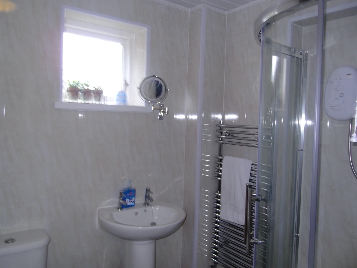 Ground floor family bathroom with bath and separate cubicle shower.